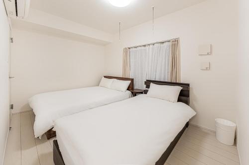 two beds sitting next to each other in a room at japan house Otsuka in Tokyo