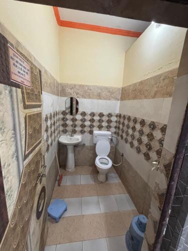 a bathroom with a toilet and a sink at Naimisharanya Ganpati dham in Naimishāranya