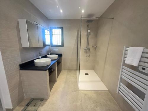 a bathroom with a sink and a glass shower at Villa MARINE in Ersa