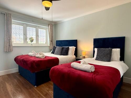 two beds in a room with red and white sheets at Halsey 4-Bed Premier Contractor Relocator Family Freeparking in Hemel Hempstead
