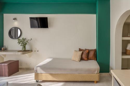 a bedroom with a bed and a green wall at Argo Cozy Studios by Estia in Malia