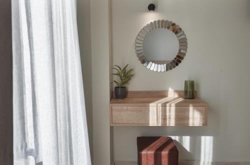 a mirror on a shelf next to a window at Argo Cozy Studios by Estia in Malia