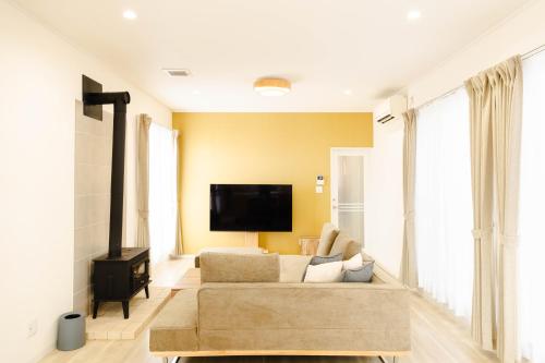 a living room with a couch and a flat screen tv at Shimabara 結 Terrace in Shimabara