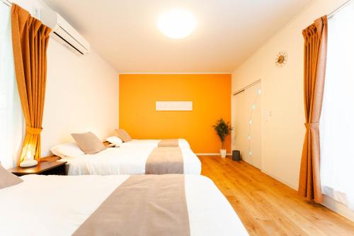 a hotel room with two beds and a window at Shimabara 結 Terrace in Shimabara