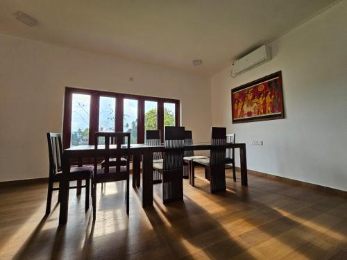 a dining room table with chairs and a painting on the wall at Alpha bungalow in Kandy
