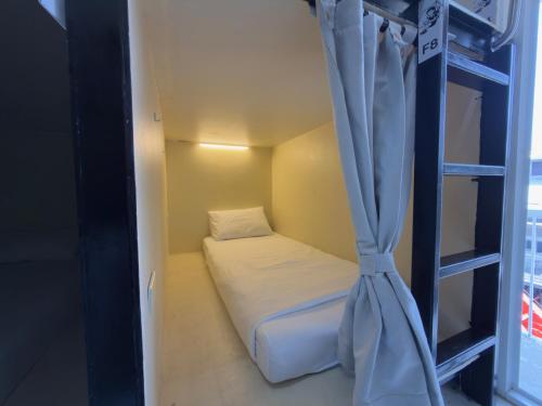 a bedroom with a bunk bed with a curtain at Nomad Yard Hostel in Bangkok