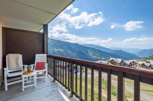a balcony with two chairs and a view of mountains at Résidence Pierre & Vacances Le Thabor in Valmeinier