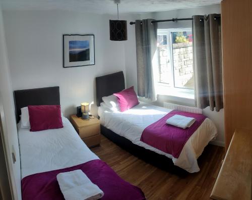 two beds in a room with a window at Palmers Apartment A in Bristol