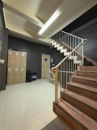 a hallway with stairs and lockers in a building at Nomad Yard Hostel in Bangkok