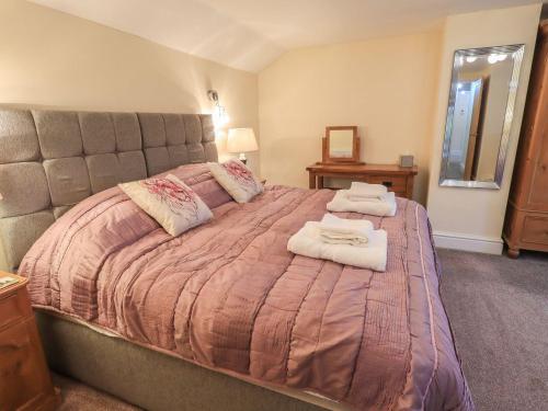a bedroom with a large bed with towels on it at Orcaber Farm Barn in Lancaster