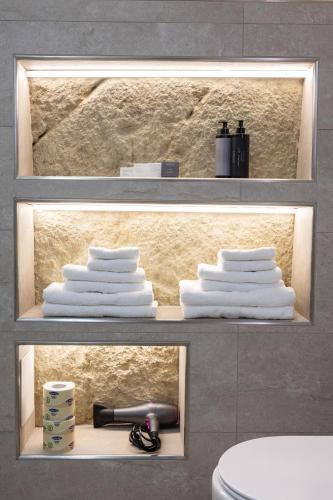 two shelves with towels and a toilet in a bathroom at Tropea Belle Époque in Tropea