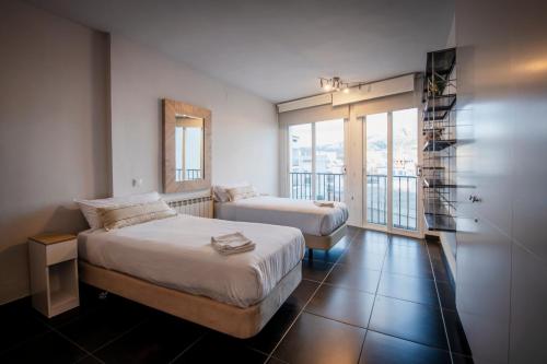 a hotel room with two beds and a balcony at Apartament Marina Roses 3 in Roses