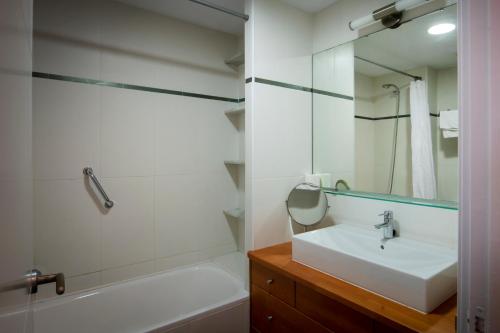 a bathroom with a sink and a tub and a mirror at Apartament Marina Roses 3 in Roses
