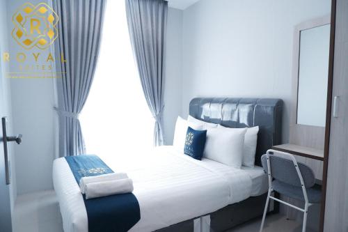 a hotel room with a bed and a chair at Royal Suites 2BR - Formosa Residence in Jodoh