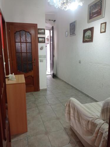 a room with a bed and a table and a door at Casa Valia in Carloforte