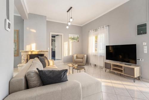 a living room with a couch and a flat screen tv at Martas Dream - Near Beach 2 Bedroom Deluxe Apartment in Daratso