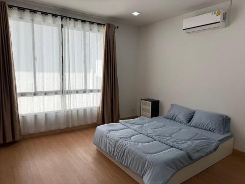 a bedroom with a bed and a large window at The Hide Private in Ban Non Sa-at