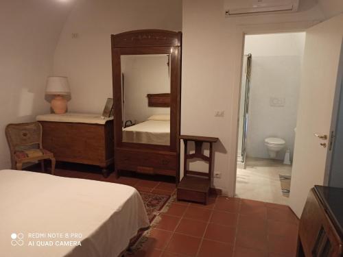 a bedroom with a mirror and a bed and a bathroom at Tenuta Patruno Perniola in Gioia del Colle