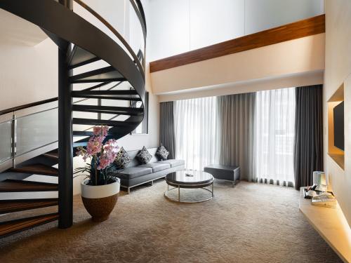 a living room with a spiral staircase and a couch at Tempus Hotel in Taichung