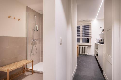 a bathroom with a shower and a bench in a room at Hotel Augustyn Brugge in Bruges