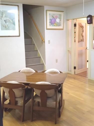 a dining room table with chairs and a staircase at Mount Villa Atami in Kannami
