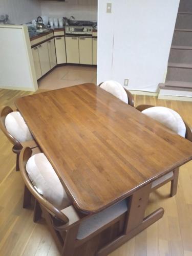 a wooden table with white chairs around it at Mount Villa Atami in Kannami