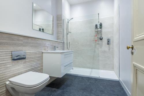 a bathroom with a white toilet and a shower at OYO Ashlea Manor in Monifieth