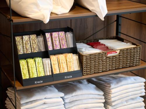 a shelf filled with books and wicker baskets at Hotel ARM ObihiroEkimae in Obihiro