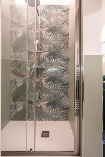 a glass door with a wall with a plant pattern at T'amo House in Macerata