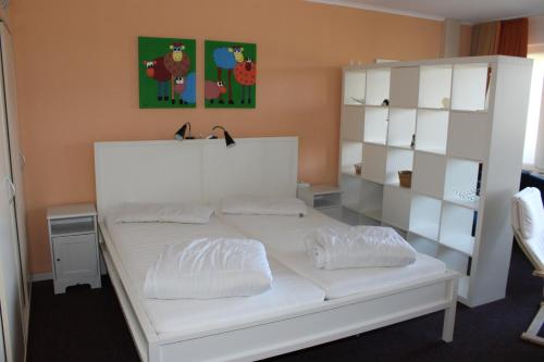 a bedroom with a white bed with white shelves at Fereinwohnung an der Ostsee E310 in Brasilien
