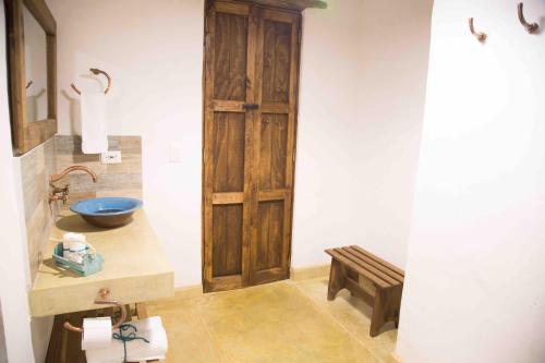 a bathroom with a sink and a wooden door at Hotel Boutique Venturi in Barichara