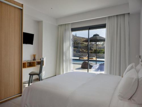 a bedroom with a bed and a view of a pool at Villa Christy in Psarou