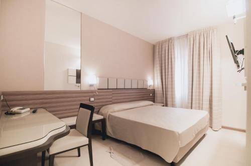 Pokój hotelowy z łóżkiem i biurkiem w obiekcie Il Cantagalli w mieście Lamezia Terme