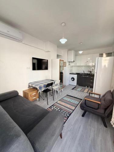 a living room with a couch and a table and a kitchen at Sahil Apart in Datca
