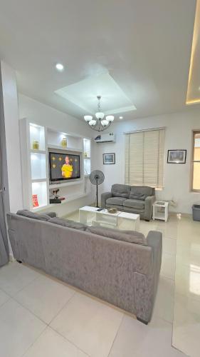 a living room with a couch and a tv at 3Apartments in Lagos