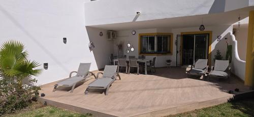 a patio with chairs and a table and a dining room at 7 Ocean Point in Sitio de Calahonda