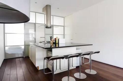 a kitchen with a black counter and some stools at Marnix360apartments Jordaan in Amsterdam