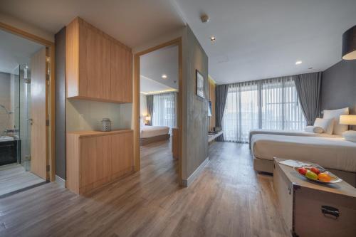 a hotel room with a bed and a bathroom at Tastoria Collection Sukhumvit in Bangkok