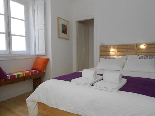 - une chambre avec un grand lit blanc et 2 chaises dans l'établissement Apartamento Alfama 28, à Lisbonne