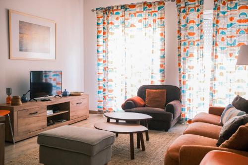 a living room with a couch and a tv at Quinta das Conchas Apartment by Trip2Portugal in Lisbon