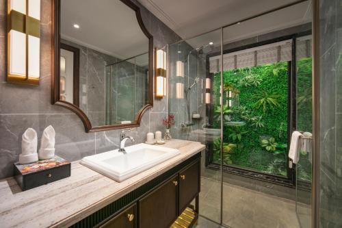 a bathroom with a sink and a shower at Heritage Ham Long Hotel and Spa in Hanoi