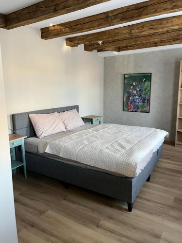 a bedroom with a large bed and a wooden floor at A33 central studio aparthotel in Liepāja