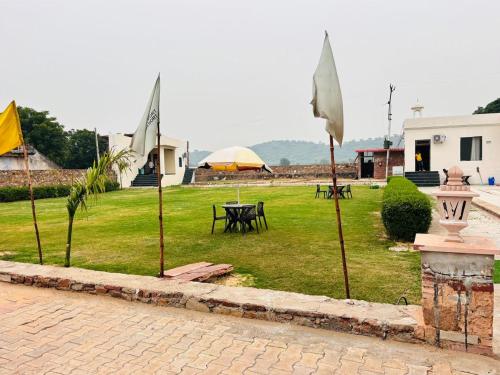 a courtyard with tables and umbrellas in a yard at Eco Fort Hotel and Resort in Mahwah