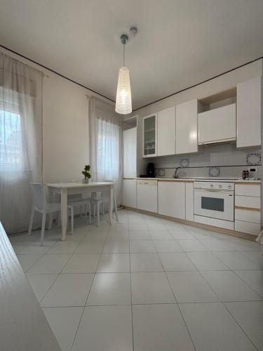 a kitchen with white cabinets and a table and a dining room at Rael in Cefalù
