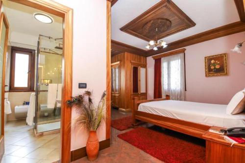 a bedroom with a bed and a bathroom with a mirror at Brilant Antik Center in Tirana
