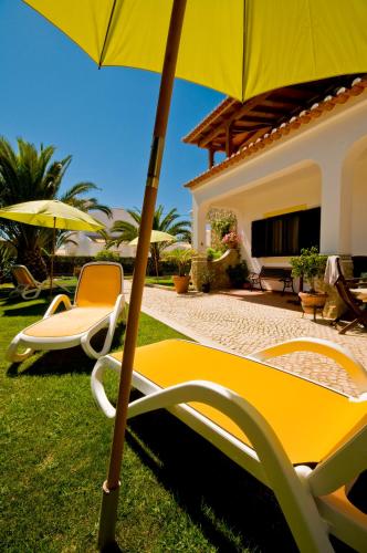 a couple of chairs and an umbrella in a yard at Residencia Julio in Sagres