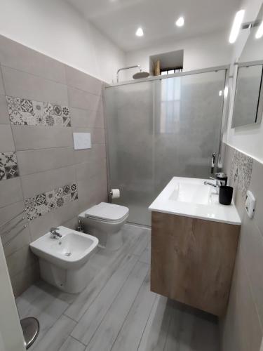 a white bathroom with a sink and a toilet at La Casetta di Nonno Settimo in Palermo