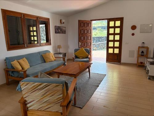 a living room with a blue couch and a table at Los Canteros de Belgara - Atlantic View Retreat in Frontera