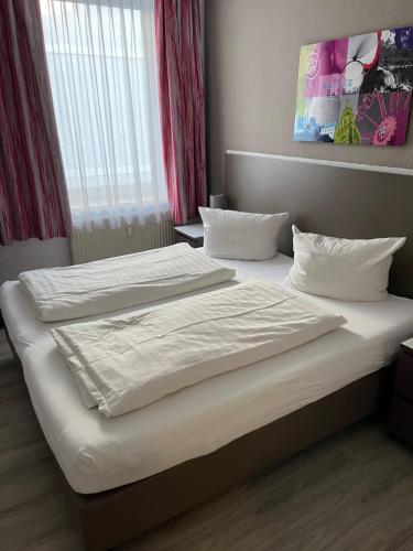 a bedroom with two beds with white sheets at Pension Belo Sono München in Munich