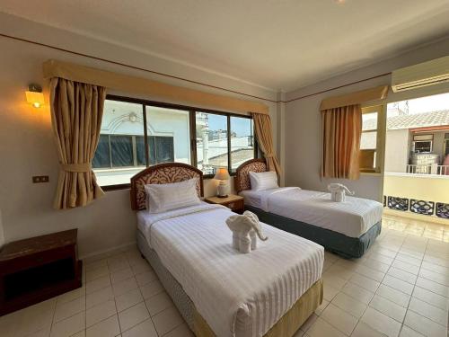 a hotel room with two beds and a window at Baan Smile in Patong Beach
